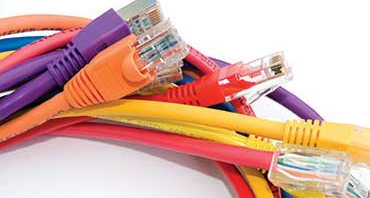 A tangled pile of orange, purple, red, and yellow ethernet cables on a white background.