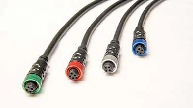 Close-up of four black cables with round, multi-pin connectors, each marked with a green, red, gray, or blue ring, on a white background.