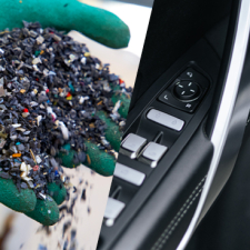 Split image: Left side shows a gloved hand holding colorful recycled plastic pellets; right side shows a close-up of black leather car door controls with metallic buttons.
